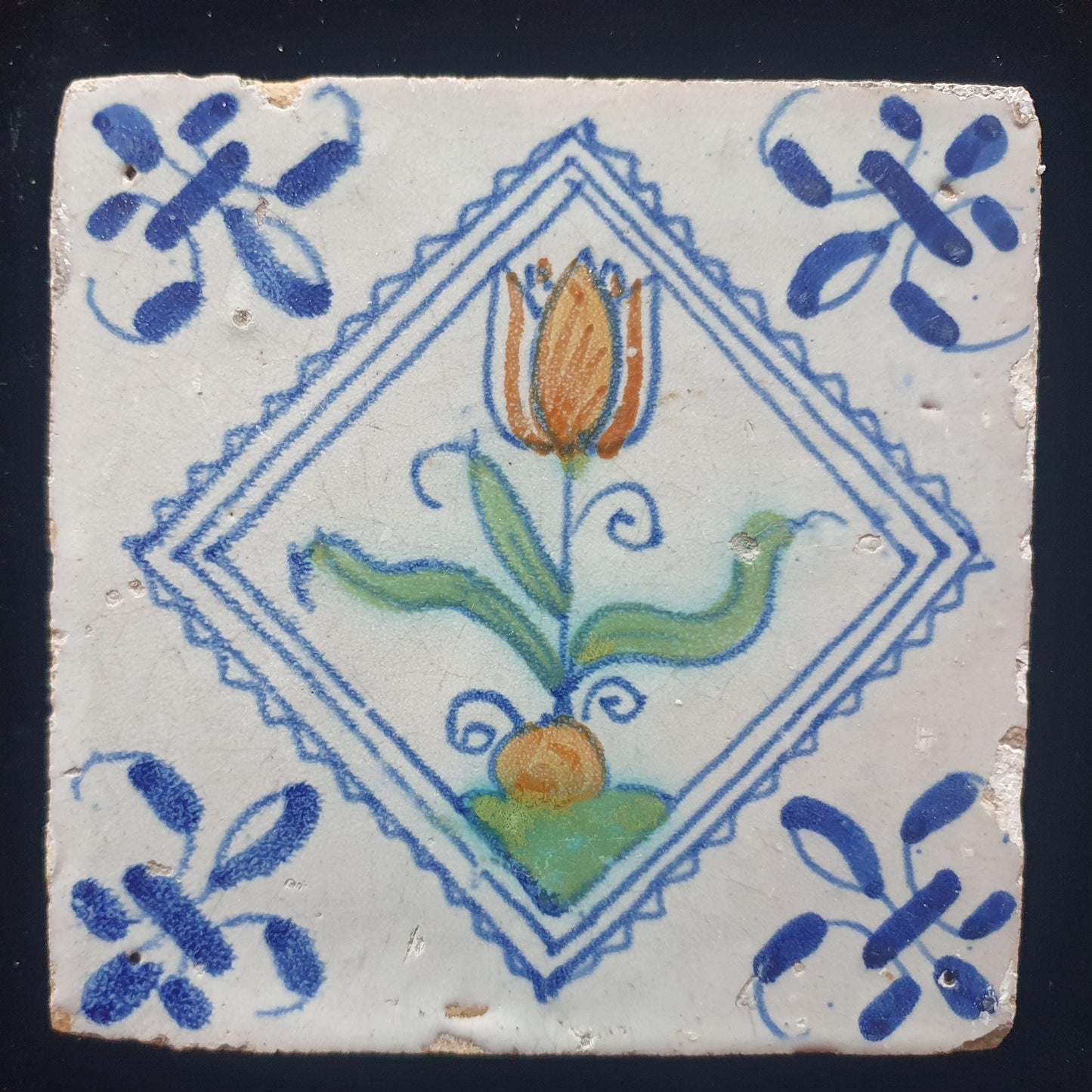 Een polychrome Hollandse tegel deze is gemaakt rond 1650 en toont een tulp in vierkant;  Dutch 17e eeuw, verzameltegel.