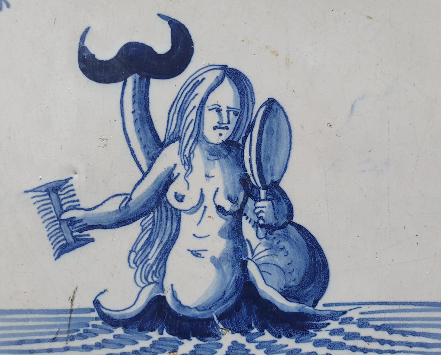 Delftse tegel toont een zeemeermin die zichzelf in een spiegel bewondert en met een kam in haar hand; Antieke 17e eeuw(1640), verzameltegel.