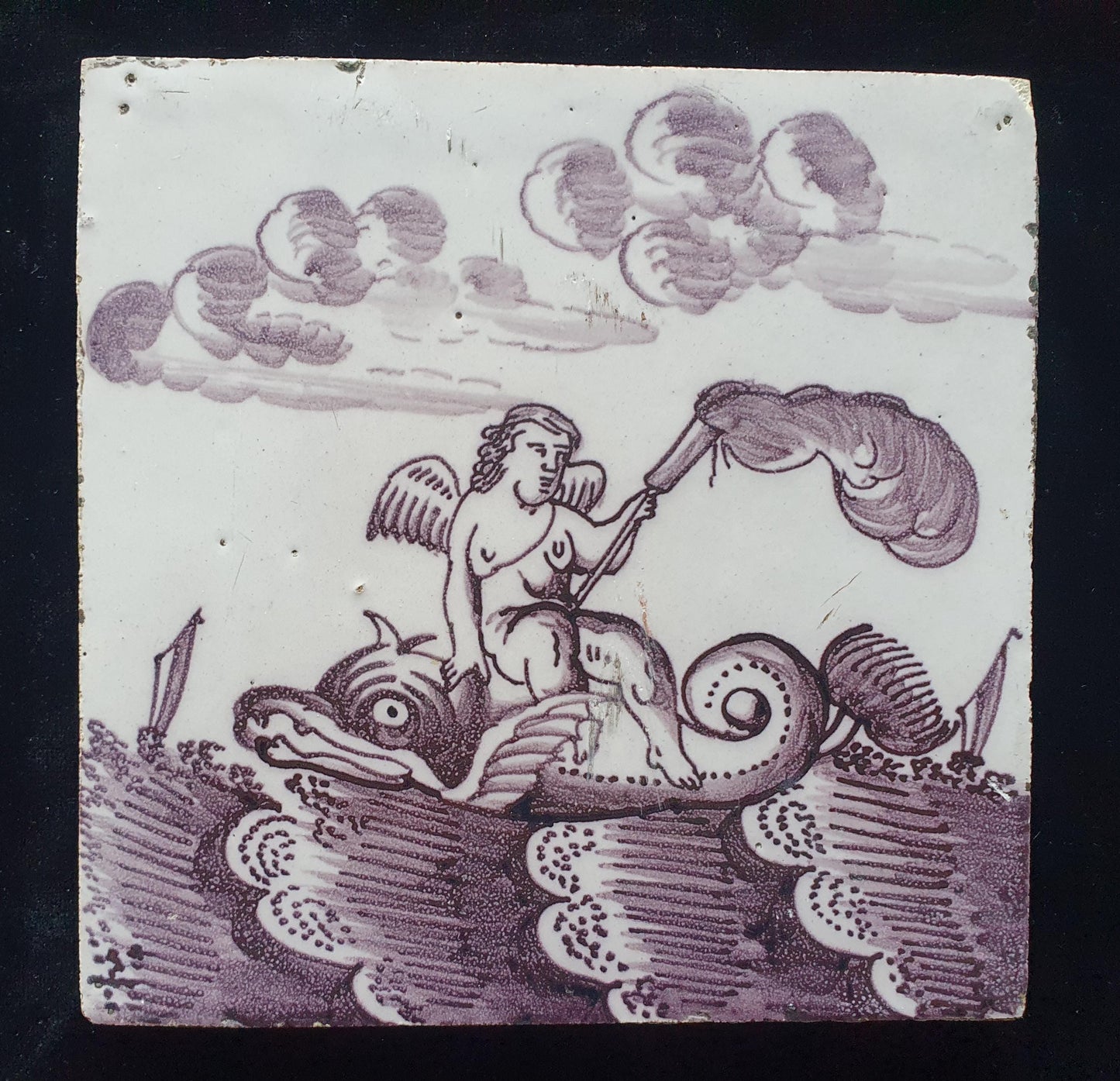 Deze antieke Delftse tegel dateert van rond 1750 en toont een putti op een monsterachtige dolfijn zit, verzameltegel.