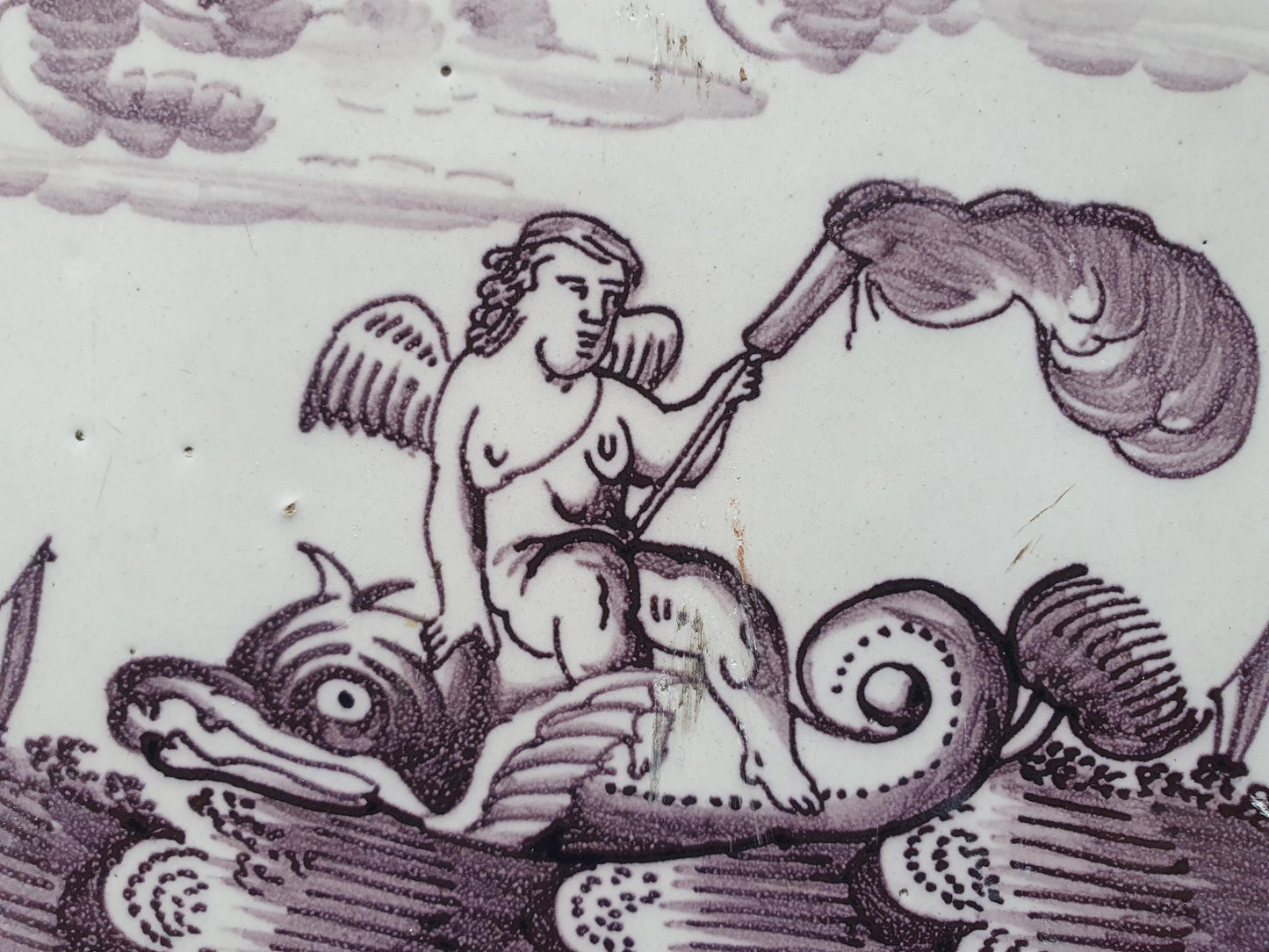 Deze antieke Delftse tegel dateert van rond 1750 en toont een putti op een monsterachtige dolfijn zit, verzameltegel.