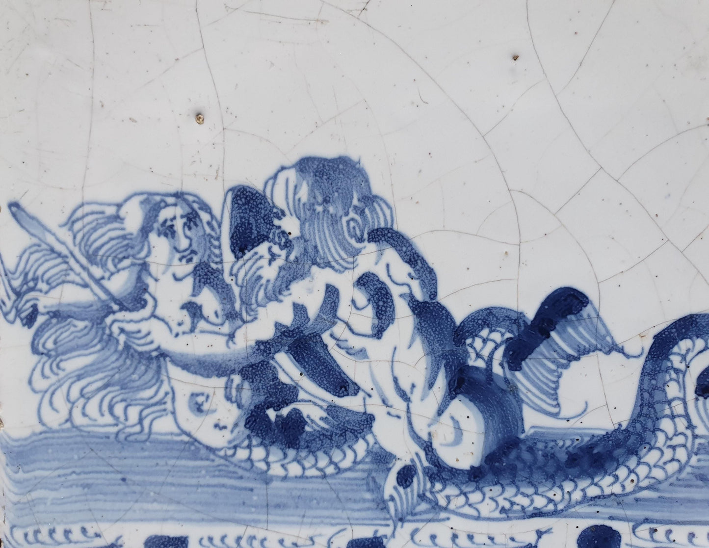 Delftse tegel toont een woest uitziende zeemeerman met zwaard die zijn vrouw vasthoudt, circa 1660 verzamel tegel.
