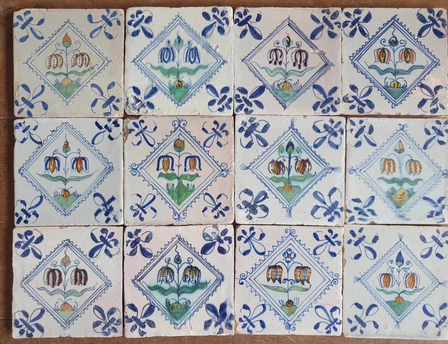 Set van 12 antieke Delftse ,Fritillaria-bloemen polychrome kwadraattegels, tilepanel 1e helft van de 17e eeuw. Delft Blue , verzameltegel, backsplash