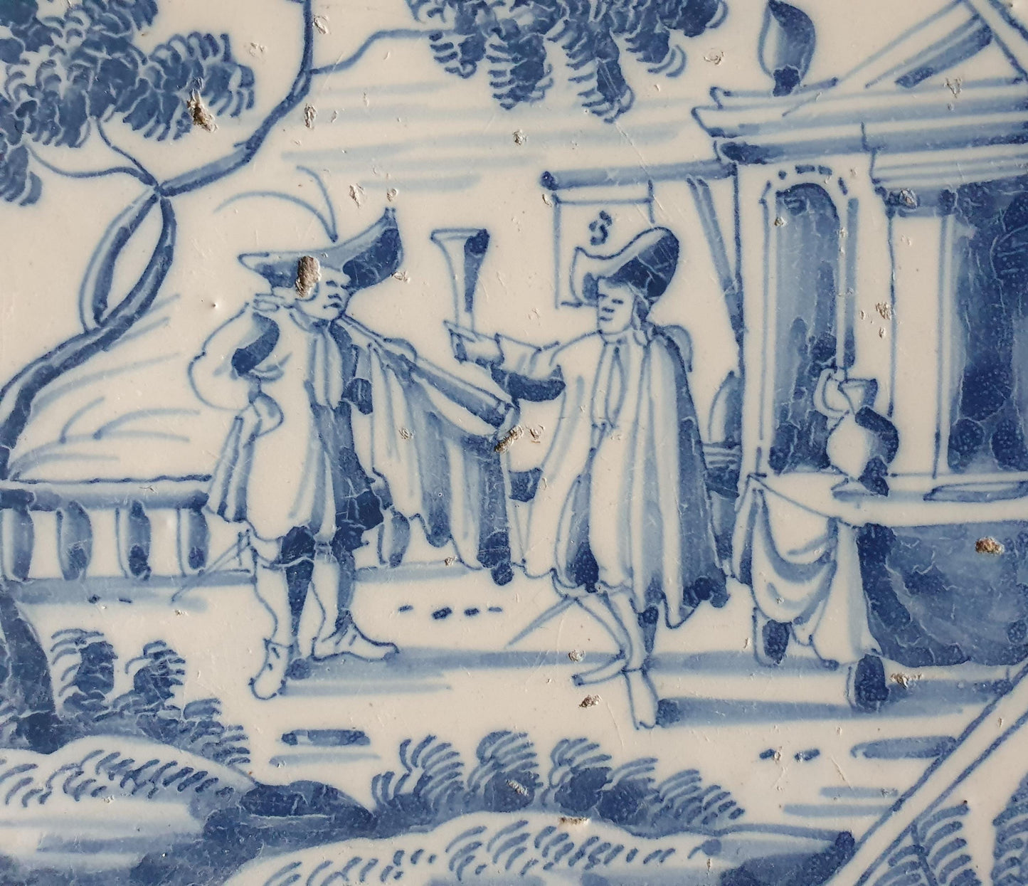 Deze fraai beschilderde Delftse tegel ( pleziertjes) toont een man die op een hoorn blaast. ; 18e eeuw (circa 1760), verzameltegel.