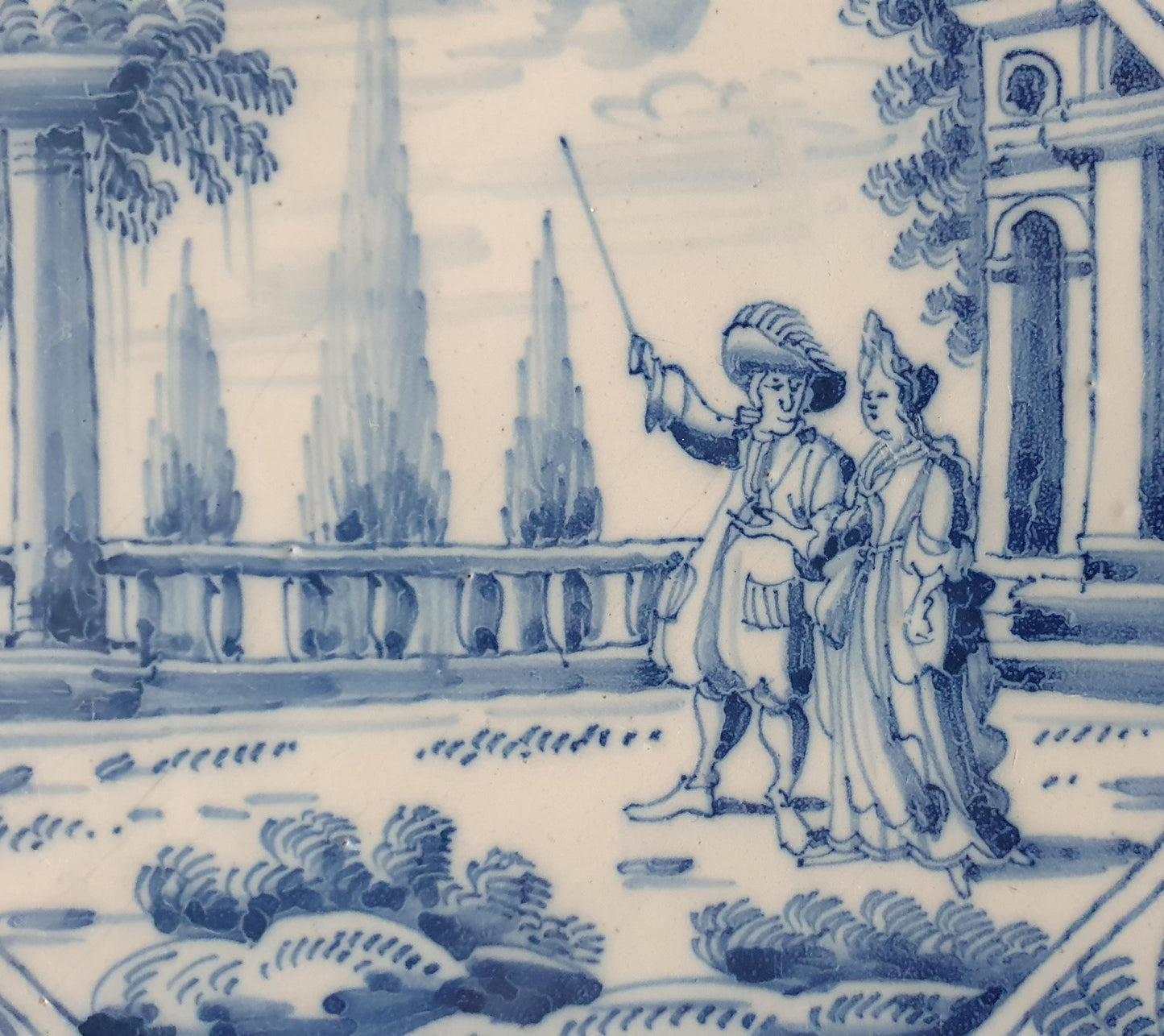 Deze fraai beschilderde Delftse tegel ( pleziertjes) toont een dame en heer met stok. ; 18e eeuw (circa 1760), verzameltegel.