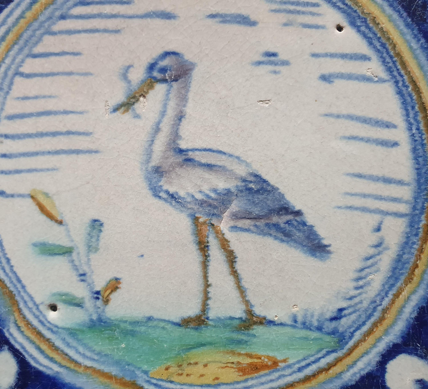 Deze zeldzame Delftse tegel uit de 17e eeuw, beschilderd rond 1620, toont een ooiervaar met in zijn bek een paling. ;  verzameltegel.