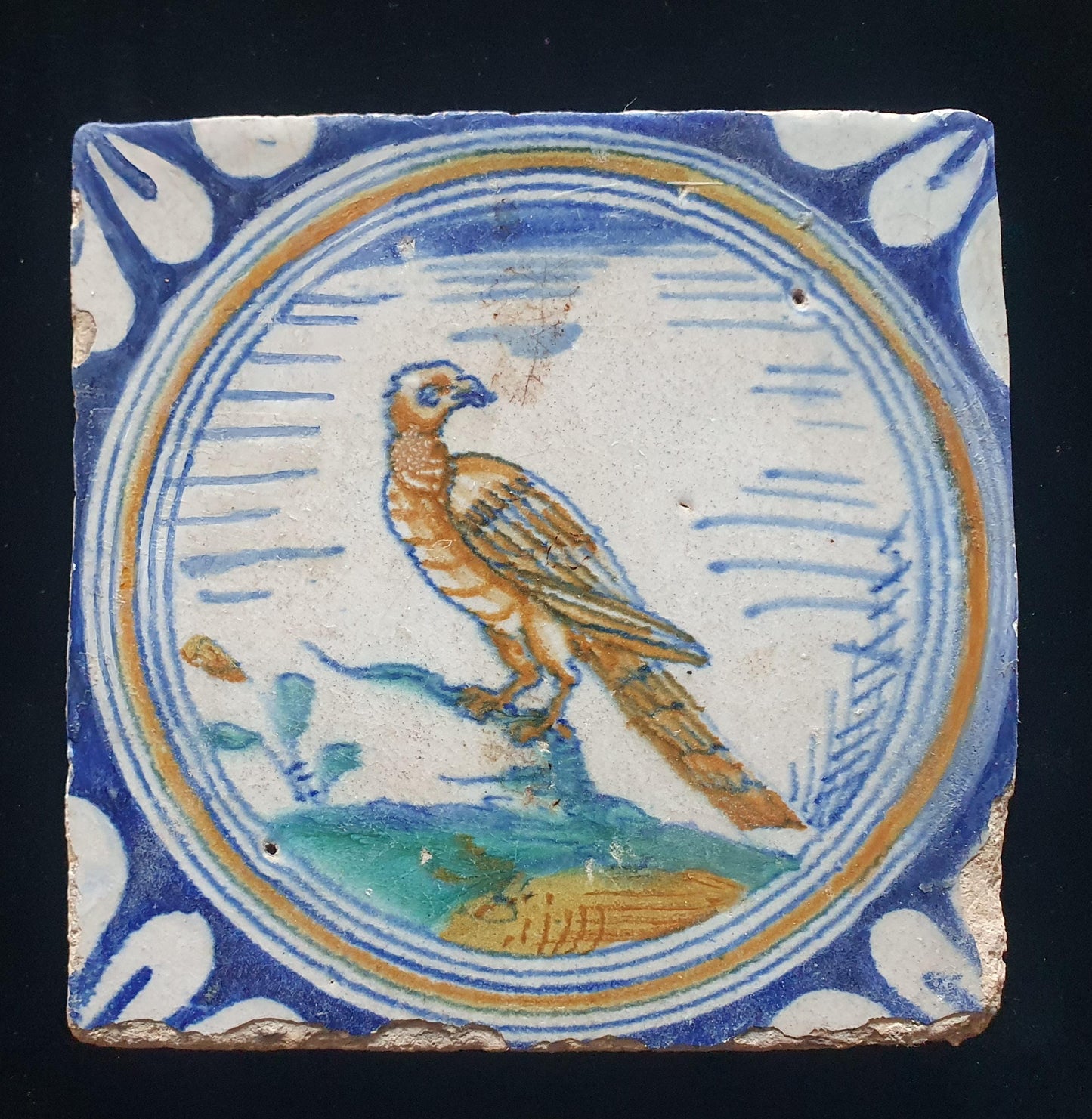 Deze zeldzame Delftse tegel uit de 17e eeuw, beschilderd rond 1620, toont een  roofvogel op een tak . ;  verzameltegel.