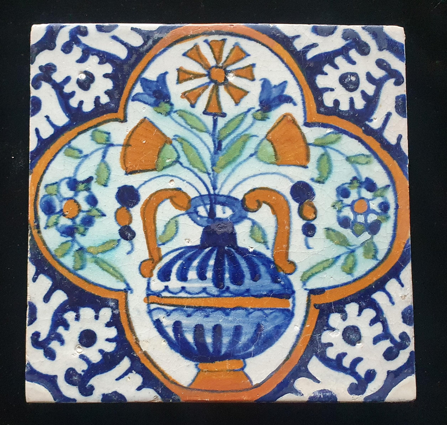 Een polychrome Nederlandse majolicategel met de decoratie van een kleurrijke bloemenvaas;  Dutch 17e eeuw, verzameltegel, backsplash