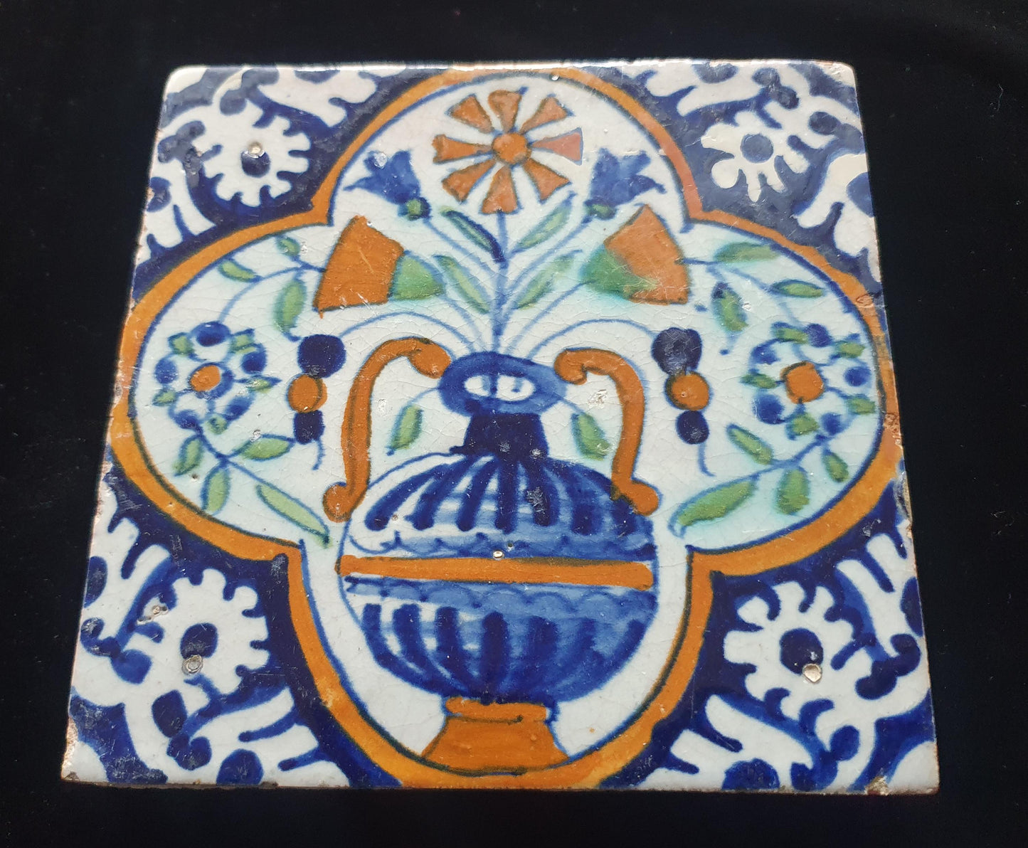 Een polychrome Nederlandse majolicategel met de decoratie van een kleurrijke bloemenvaas;  Dutch 17e eeuw, verzameltegel, backsplash