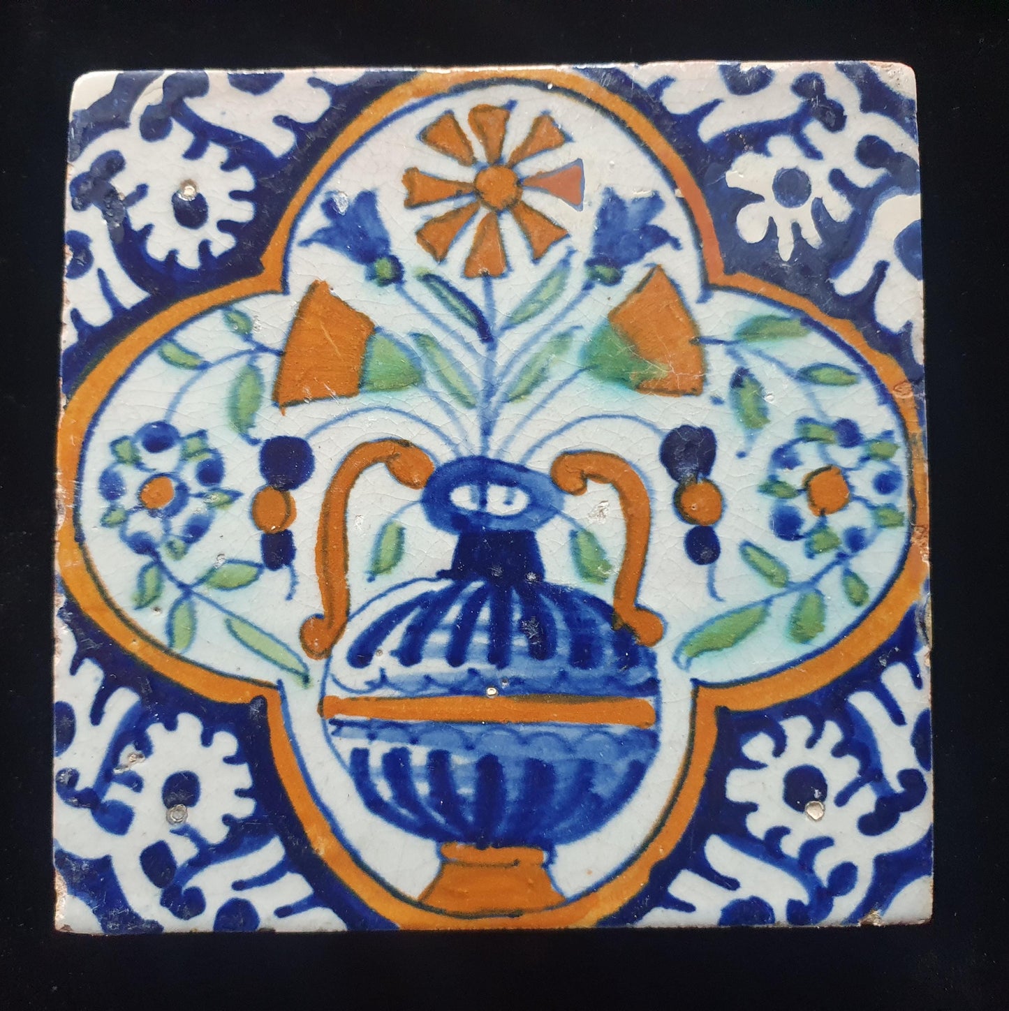 Een polychrome Nederlandse majolicategel met de decoratie van een kleurrijke bloemenvaas;  Dutch 17e eeuw, verzameltegel, backsplash
