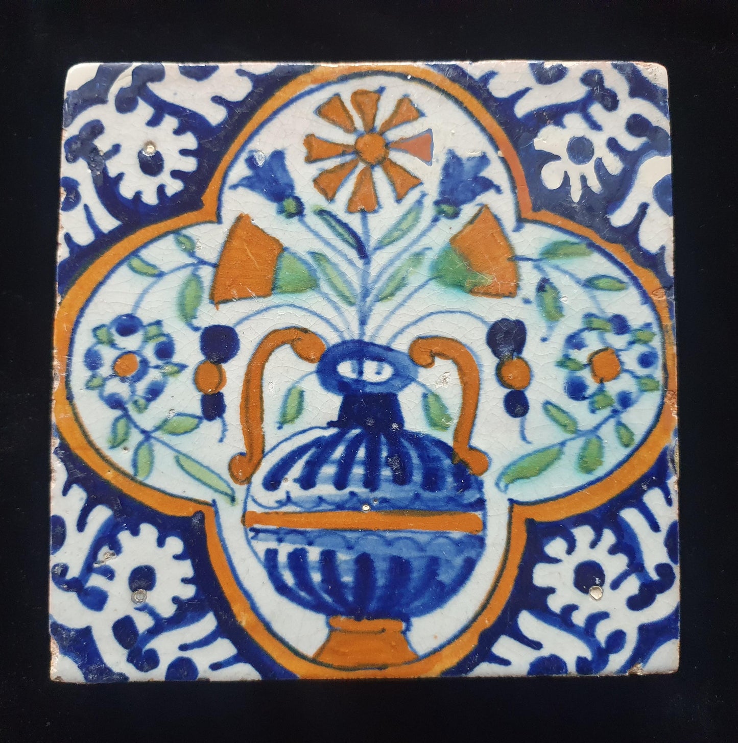 Een polychrome Nederlandse majolicategel met de decoratie van een kleurrijke bloemenvaas;  Dutch 17e eeuw, verzameltegel, backsplash
