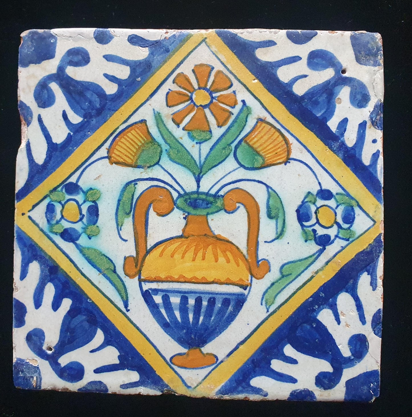 Een polychrome Nederlandse majolicategel met de decoratie van een kleurrijke bloemenvaas;  Dutch 17e eeuw, verzameltegel, backsplash