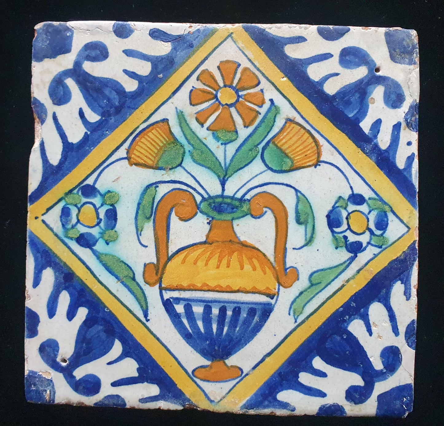 Een polychrome Nederlandse majolicategel met de decoratie van een kleurrijke bloemenvaas;  Dutch 17e eeuw, verzameltegel, backsplash
