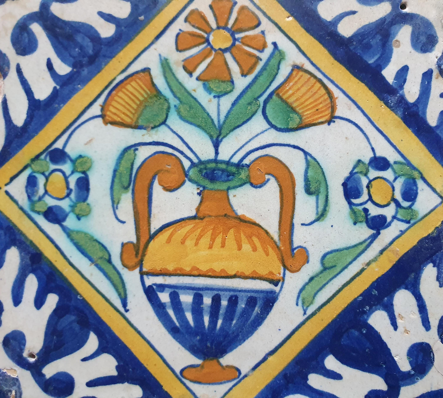 Een polychrome Nederlandse majolicategel met de decoratie van een kleurrijke bloemenvaas;  Dutch 17e eeuw, verzameltegel, backsplash