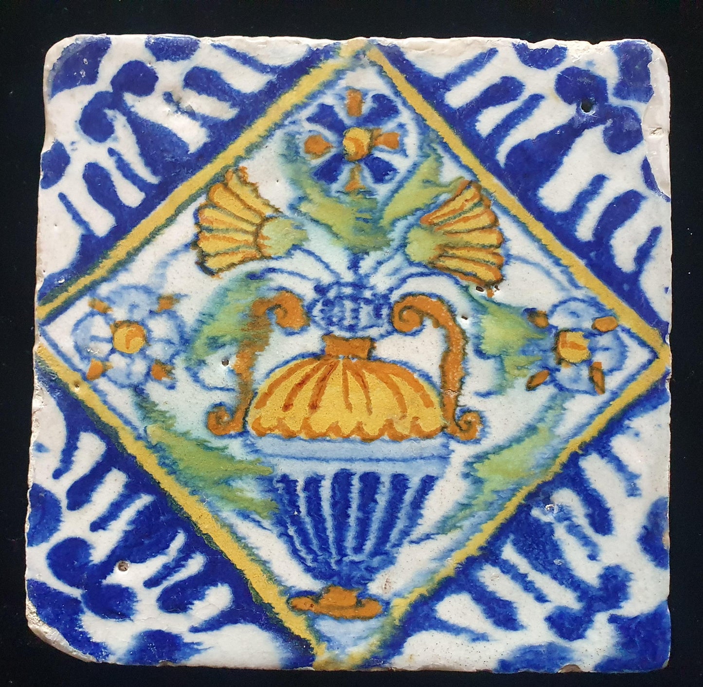 Een polychrome Nederlandse majolicategel met de decoratie van een kleurrijke bloemenvaas;  Dutch 17e eeuw, verzameltegel, backsplash