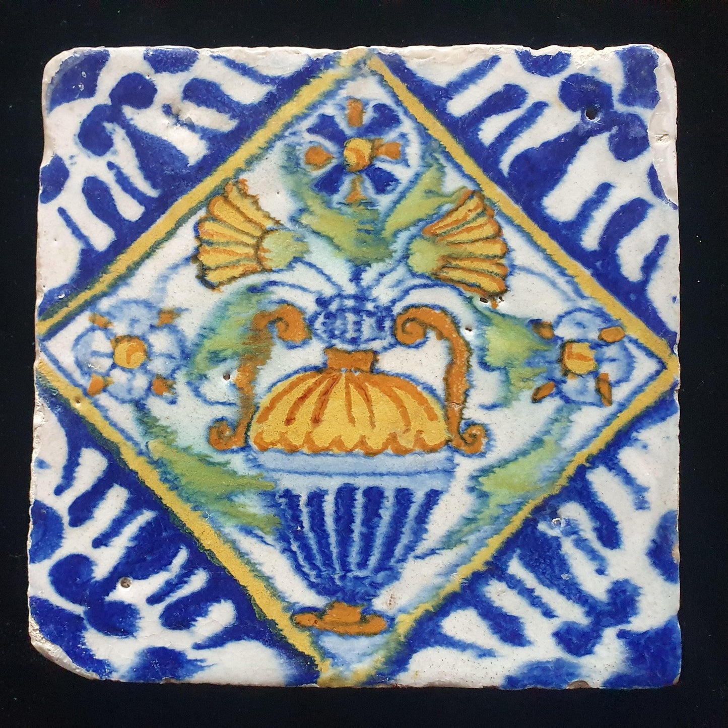 Een polychrome Nederlandse majolicategel met de decoratie van een kleurrijke bloemenvaas;  Dutch 17e eeuw, verzameltegel, backsplash