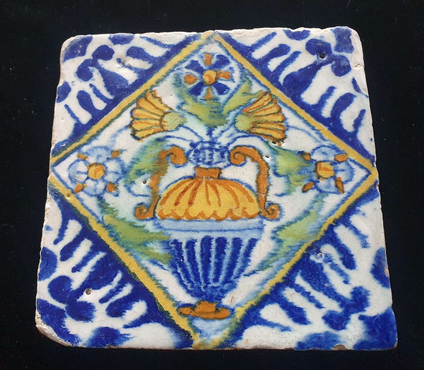 Een polychrome Nederlandse majolicategel met de decoratie van een kleurrijke bloemenvaas;  Dutch 17e eeuw, verzameltegel, backsplash