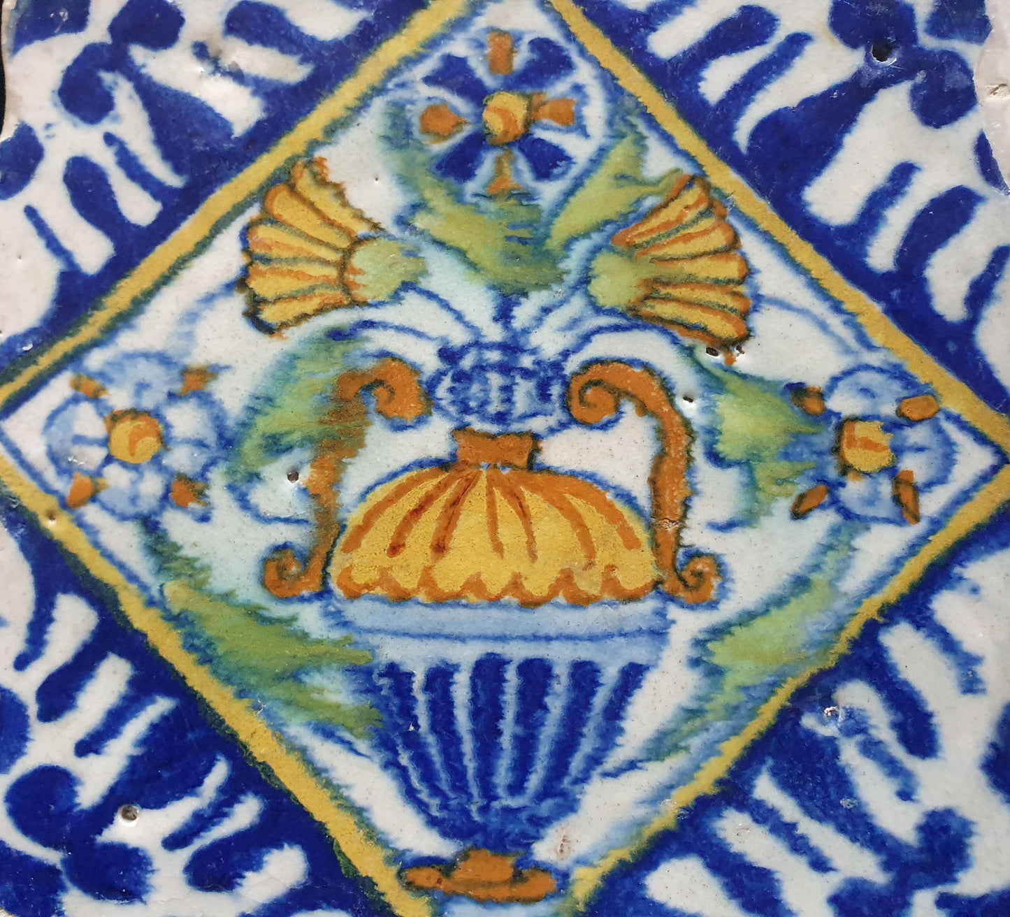 Een polychrome Nederlandse majolicategel met de decoratie van een kleurrijke bloemenvaas;  Dutch 17e eeuw, verzameltegel, backsplash
