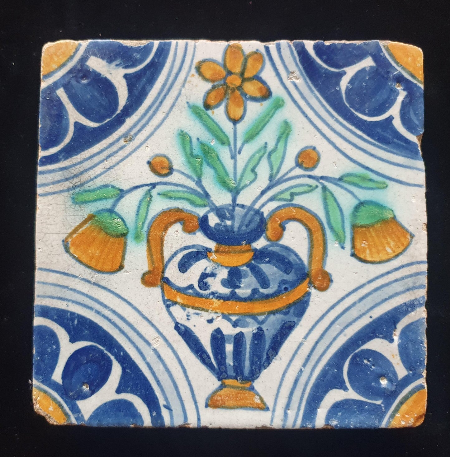 Een polychrome Nederlandse majolicategel met de decoratie van een kleurrijke bloemenvaas;  Dutch 17e eeuw, verzameltegel, backsplash