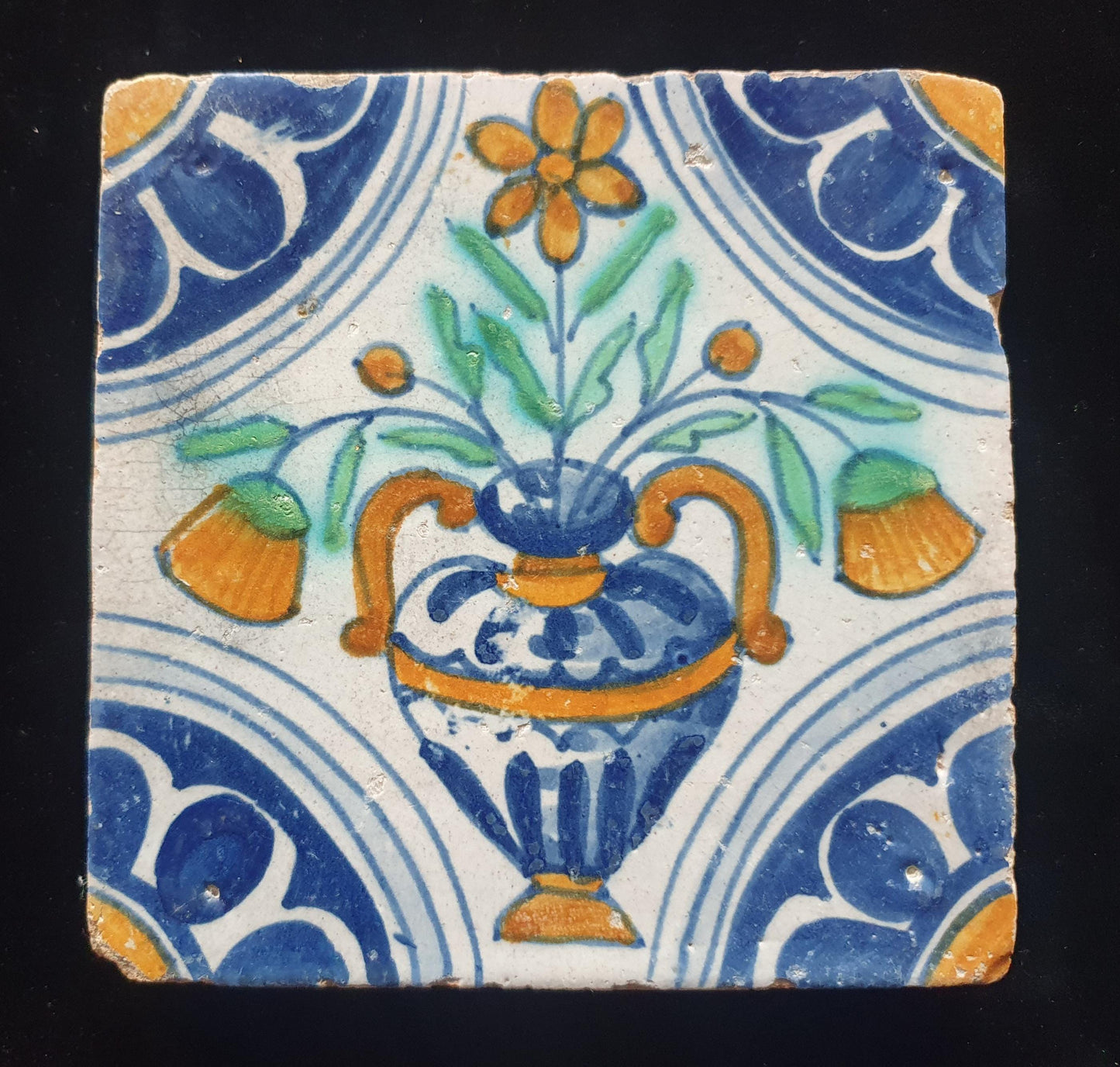 Een polychrome Nederlandse majolicategel met de decoratie van een kleurrijke bloemenvaas;  Dutch 17e eeuw, verzameltegel, backsplash