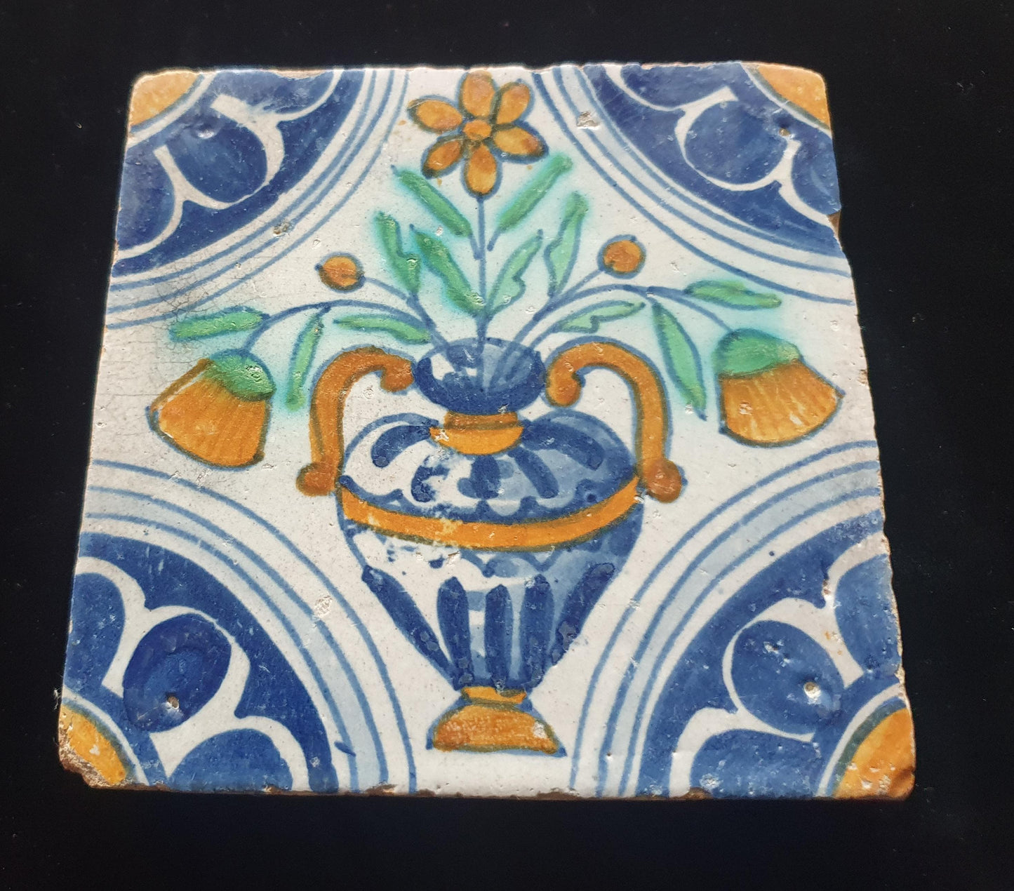 Een polychrome Nederlandse majolicategel met de decoratie van een kleurrijke bloemenvaas;  Dutch 17e eeuw, verzameltegel, backsplash