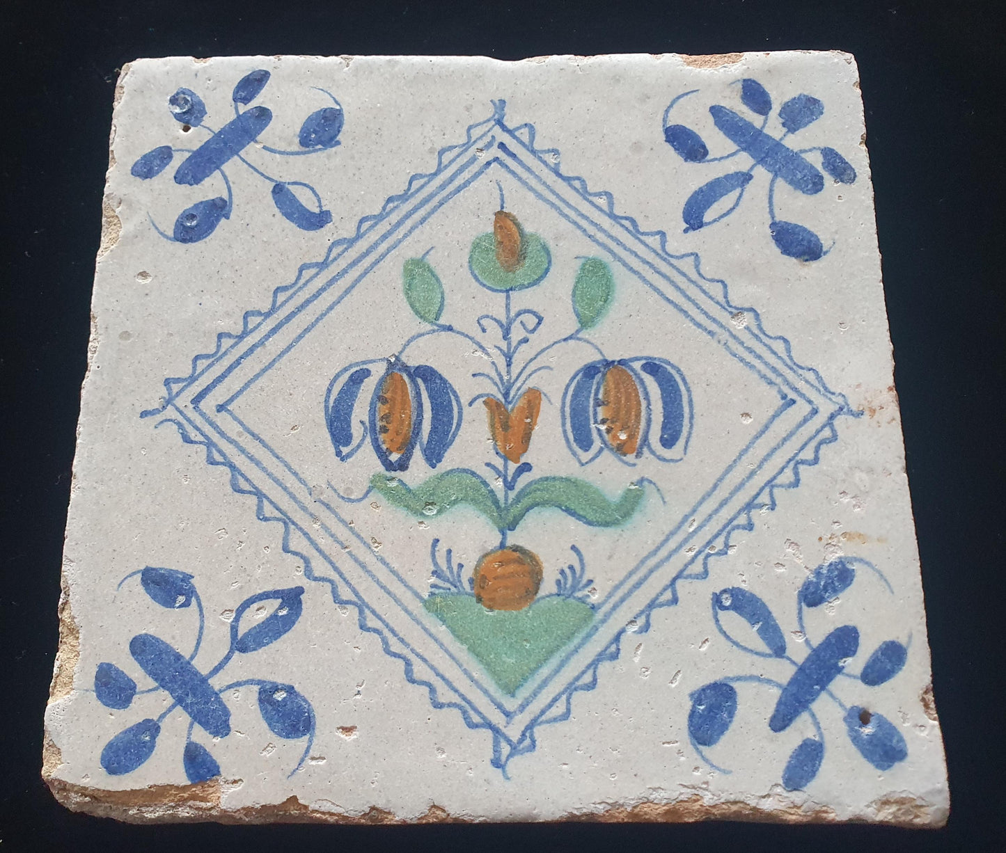 Een polychrome Hollandse tegel deze is gemaakt rond 1650 en toont een Fritillaria (Slangenkopbloem);  Dutch 17e eeuw, verzameltegel.