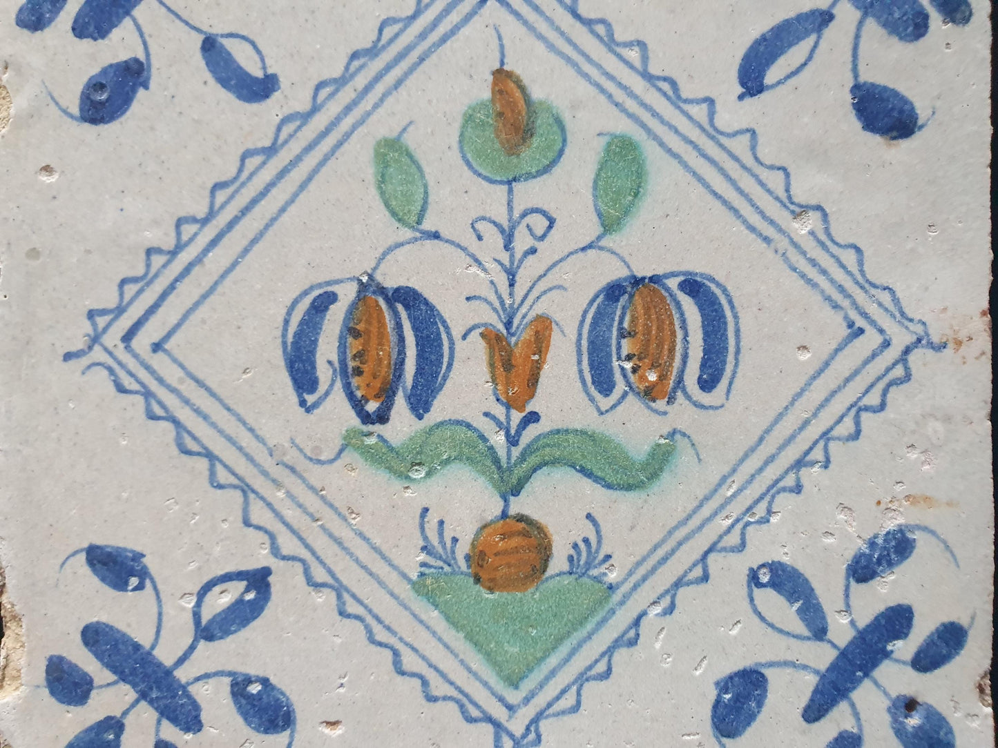 Een polychrome Hollandse tegel deze is gemaakt rond 1650 en toont een Fritillaria (Slangenkopbloem);  Dutch 17e eeuw, verzameltegel.