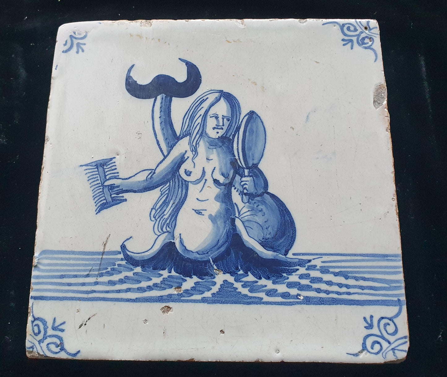 Delftse tegel toont een zeemeermin die zichzelf in een spiegel bewondert en met een kam in haar hand; Antieke 17e eeuw(1640), verzameltegel.