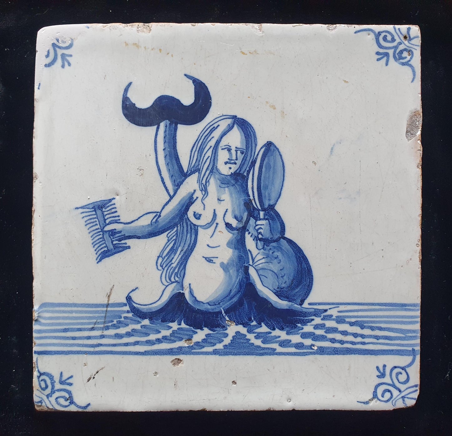 Delftse tegel toont een zeemeermin die zichzelf in een spiegel bewondert en met een kam in haar hand; Antieke 17e eeuw(1640), verzameltegel.