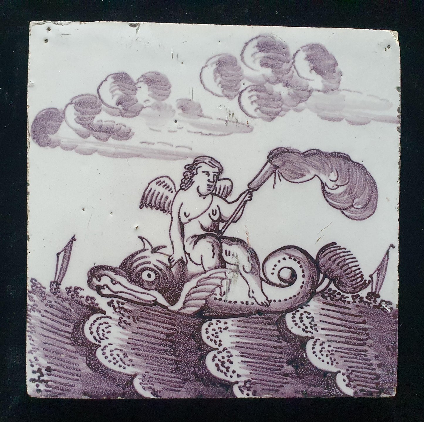 Deze antieke Delftse tegel dateert van rond 1750 en toont een putti op een monsterachtige dolfijn zit, verzameltegel.
