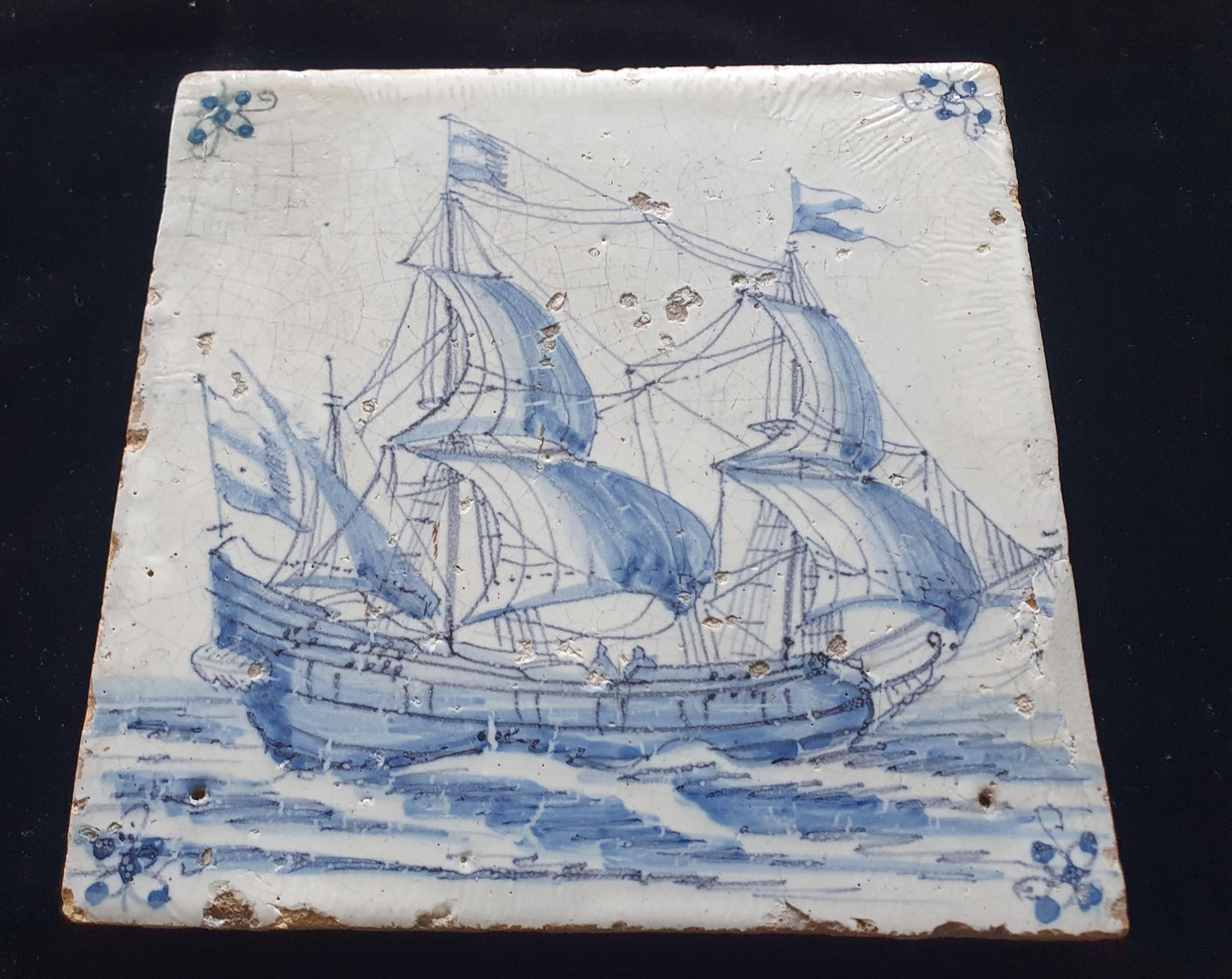 Deze antieke Delftse tegel is waarschijnlijk gemaakt in Amsterdam rond 1660. De tegel toont een Fluyt onder zeil. verzamel tegel.