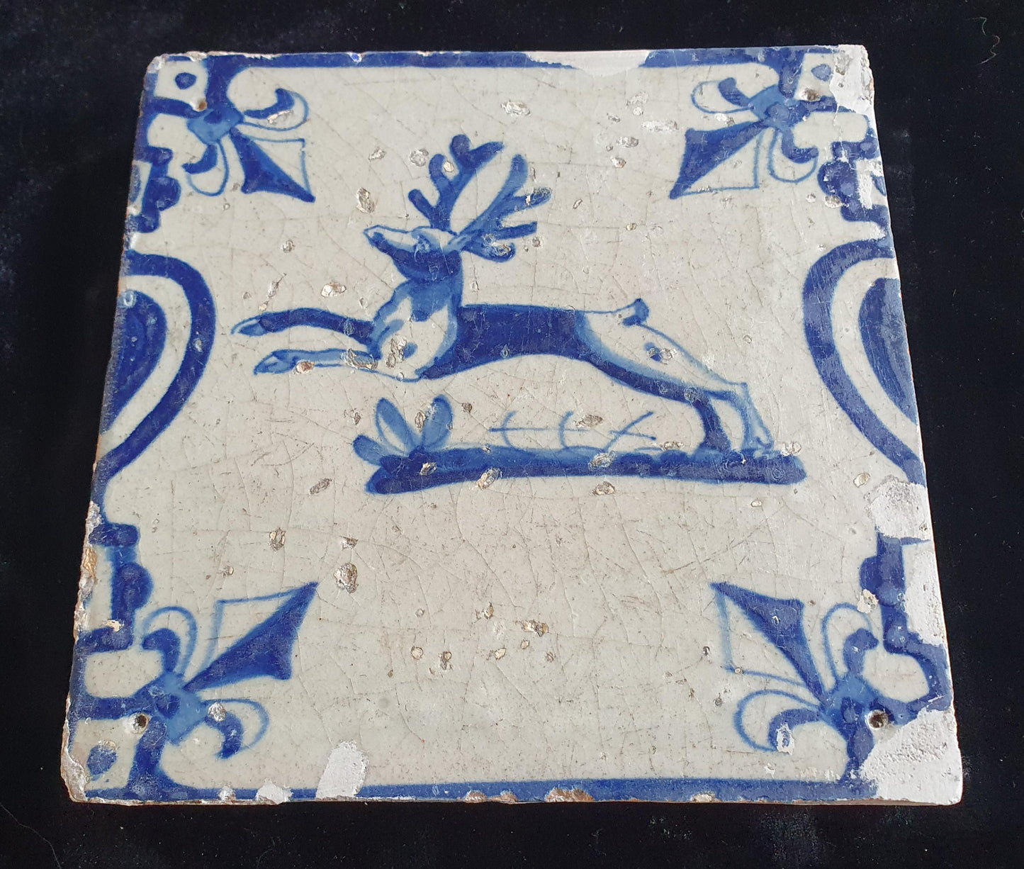 This 17th century Delft tile depicts a jumping deer , delicately painted in blue