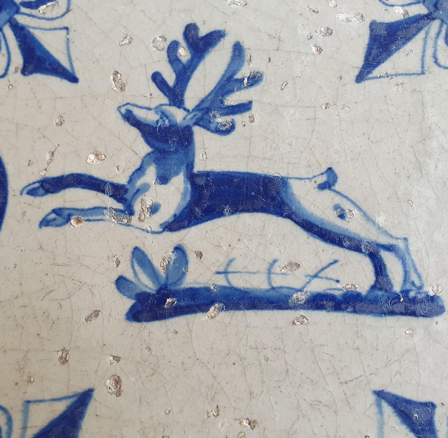 This 17th century Delft tile depicts a jumping deer , delicately painted in blue