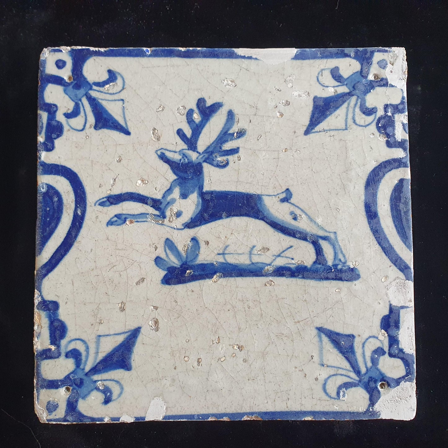 This 17th century Delft tile depicts a jumping deer , delicately painted in blue