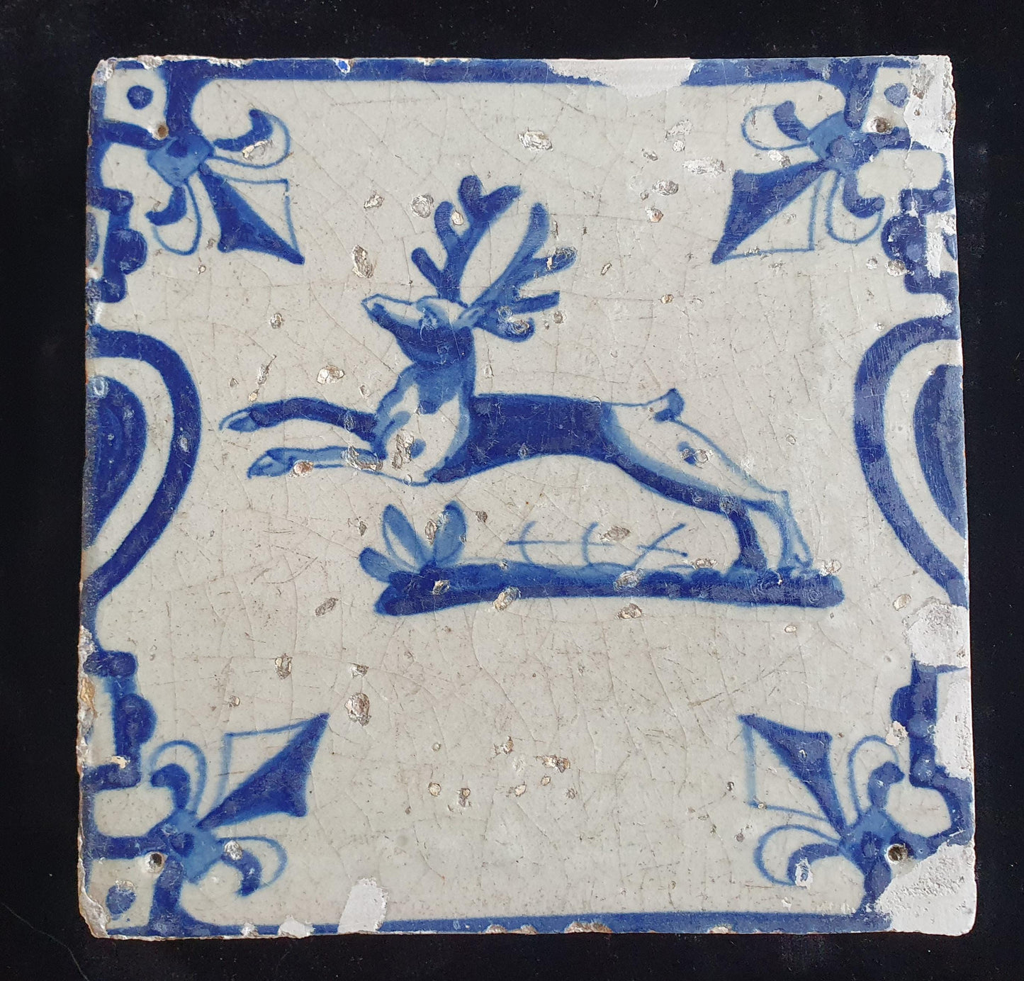 This 17th century Delft tile depicts a jumping deer , delicately painted in blue