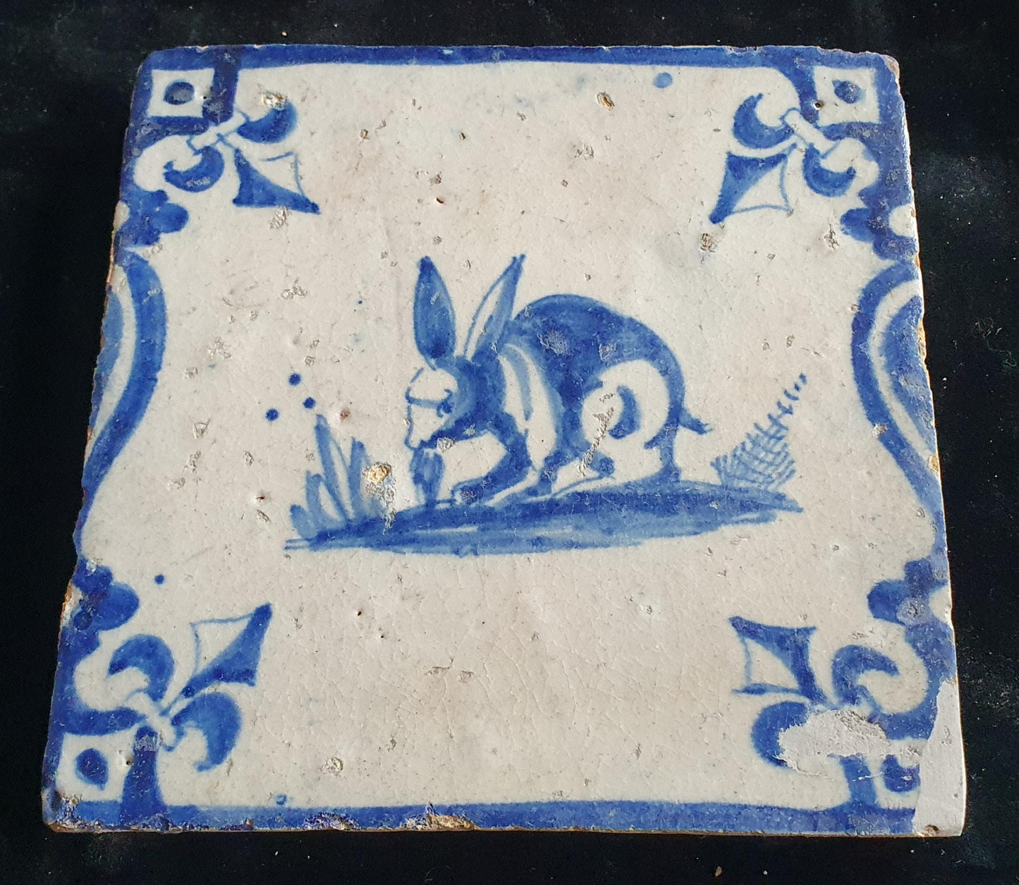 This 17th century Delft tile depicts a jumping hare , delicately painted in blue