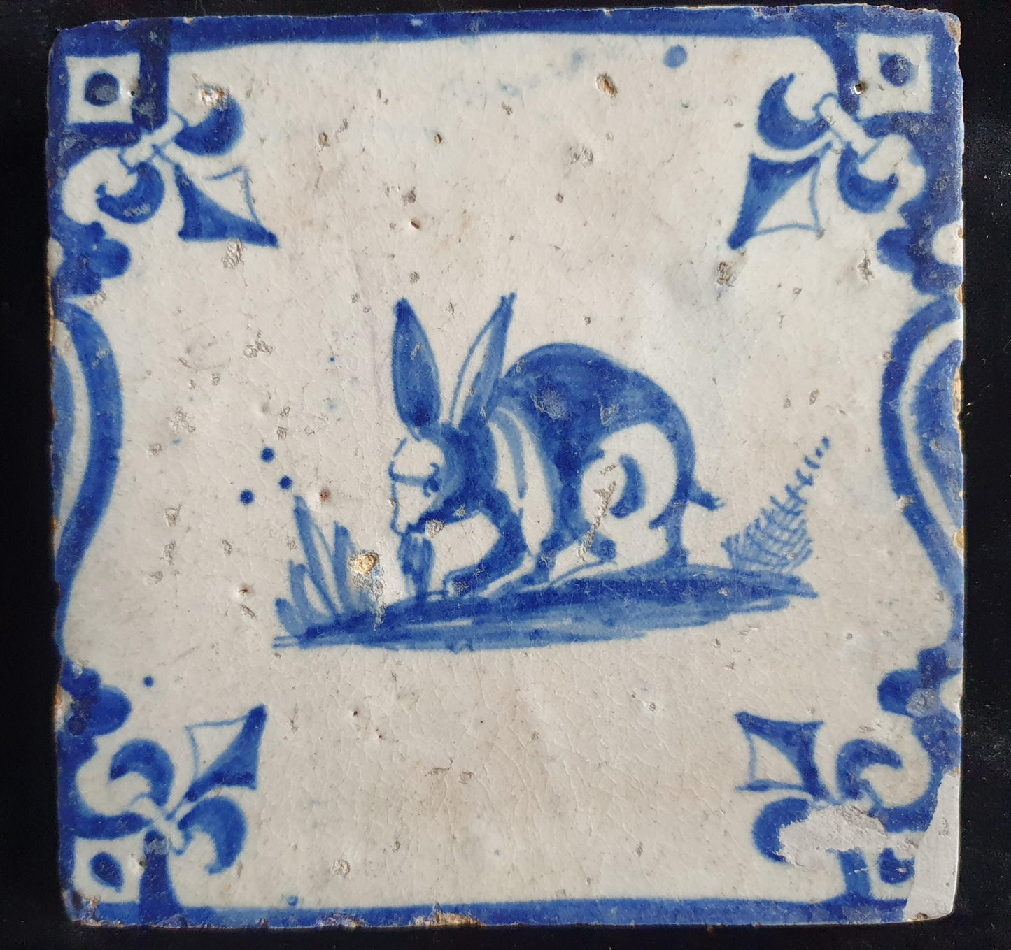 This 17th century Delft tile depicts a jumping hare , delicately painted in blue