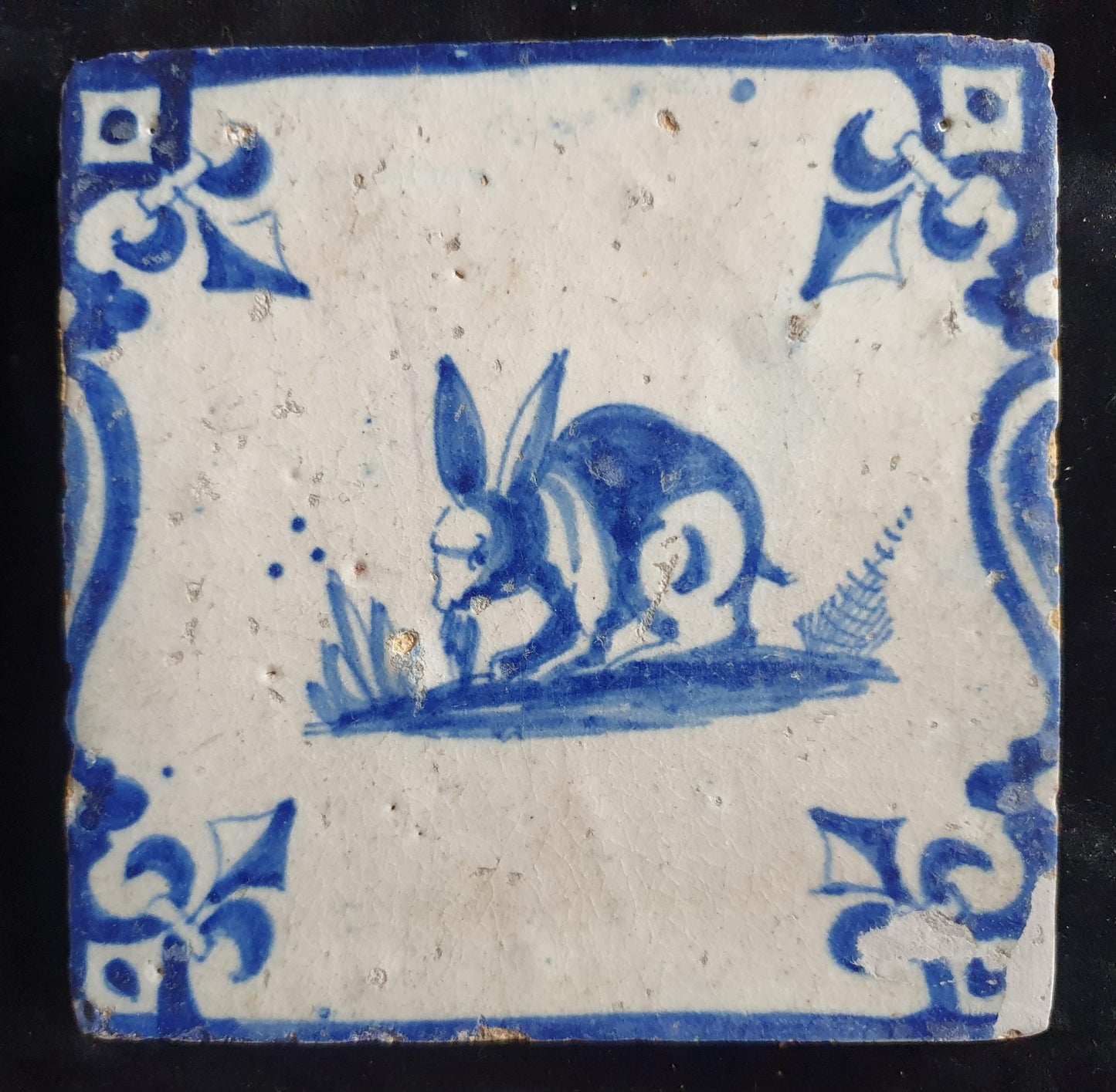 This 17th century Delft tile depicts a jumping hare , delicately painted in blue