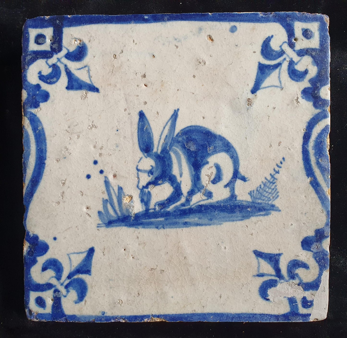 This 17th century Delft tile depicts a jumping hare , delicately painted in blue
