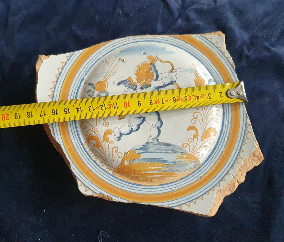 A rare, large shard from a plate, featuring a depiction on the base of a striding putto with a bow and arrow. 17th