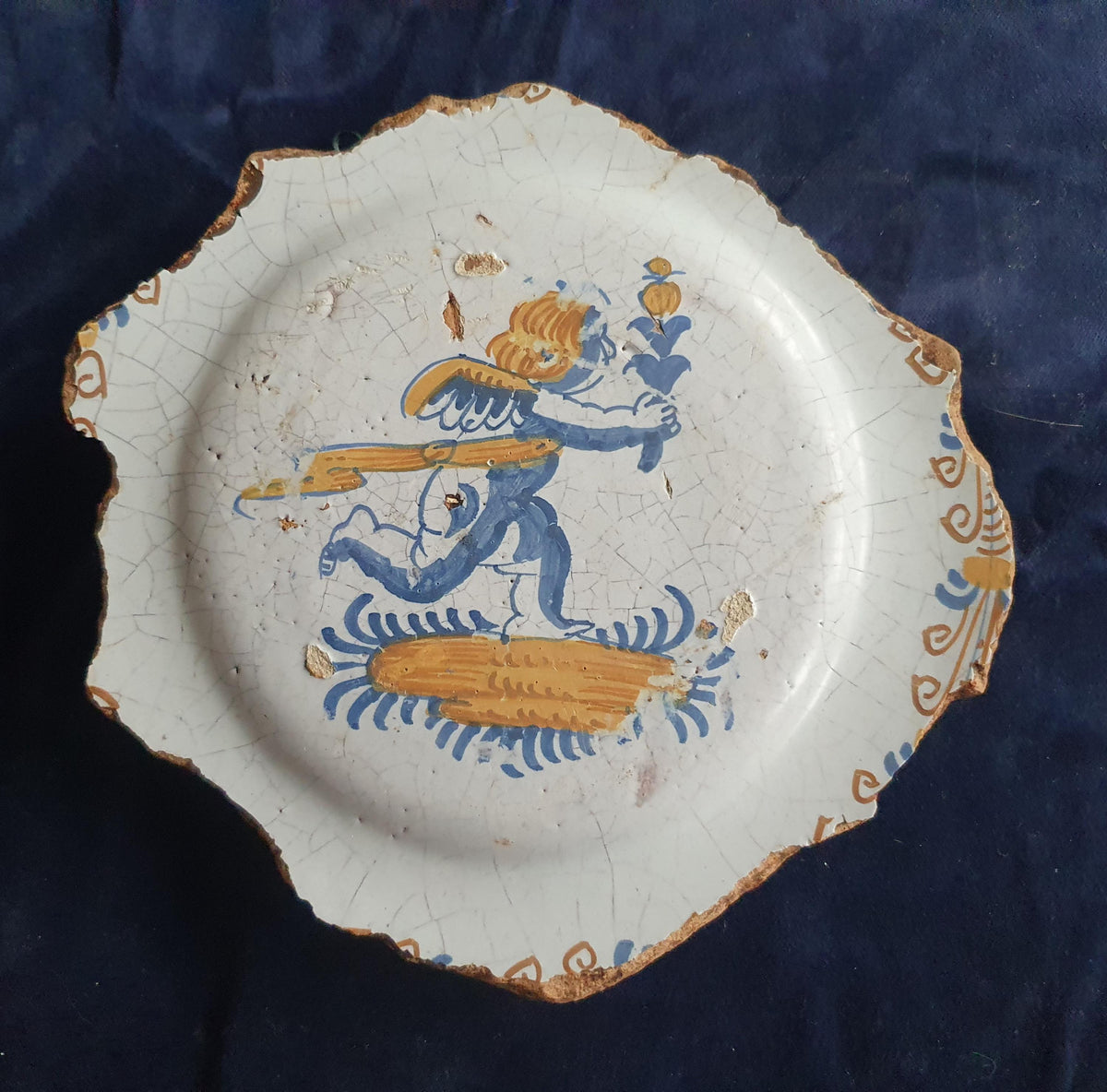 A rare, large shard from a plate, featuring a depiction on the base of a striding putto with a flower. 17th.