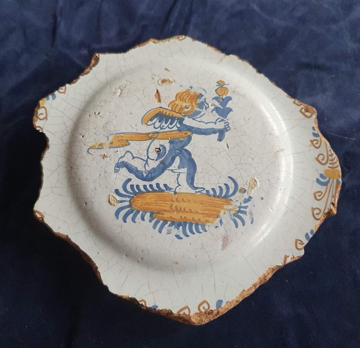 A rare, large shard from a plate, featuring a depiction on the base of a striding putto with a flower. 17th.