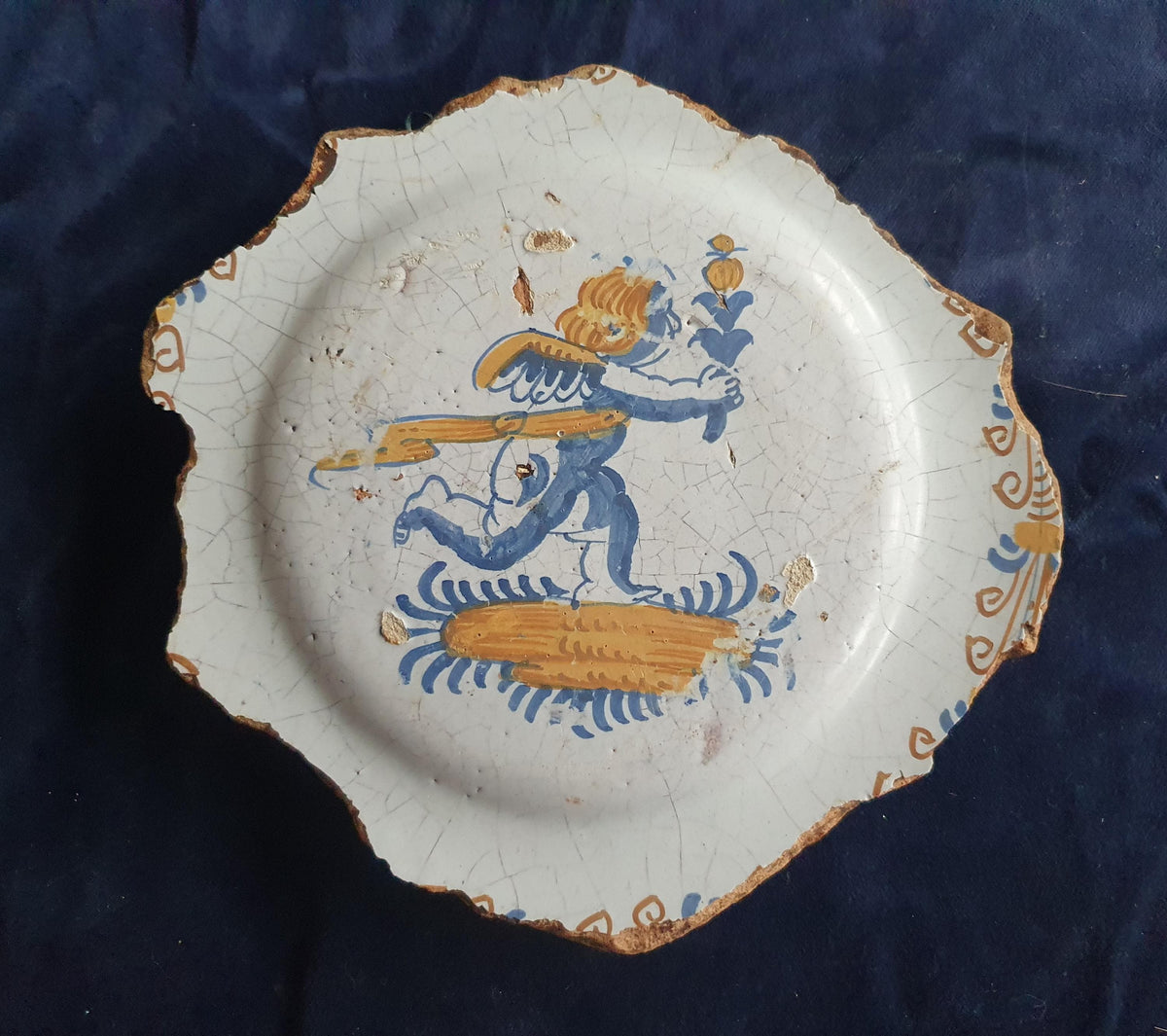 A rare, large shard from a plate, featuring a depiction on the base of a striding putto with a flower. 17th.