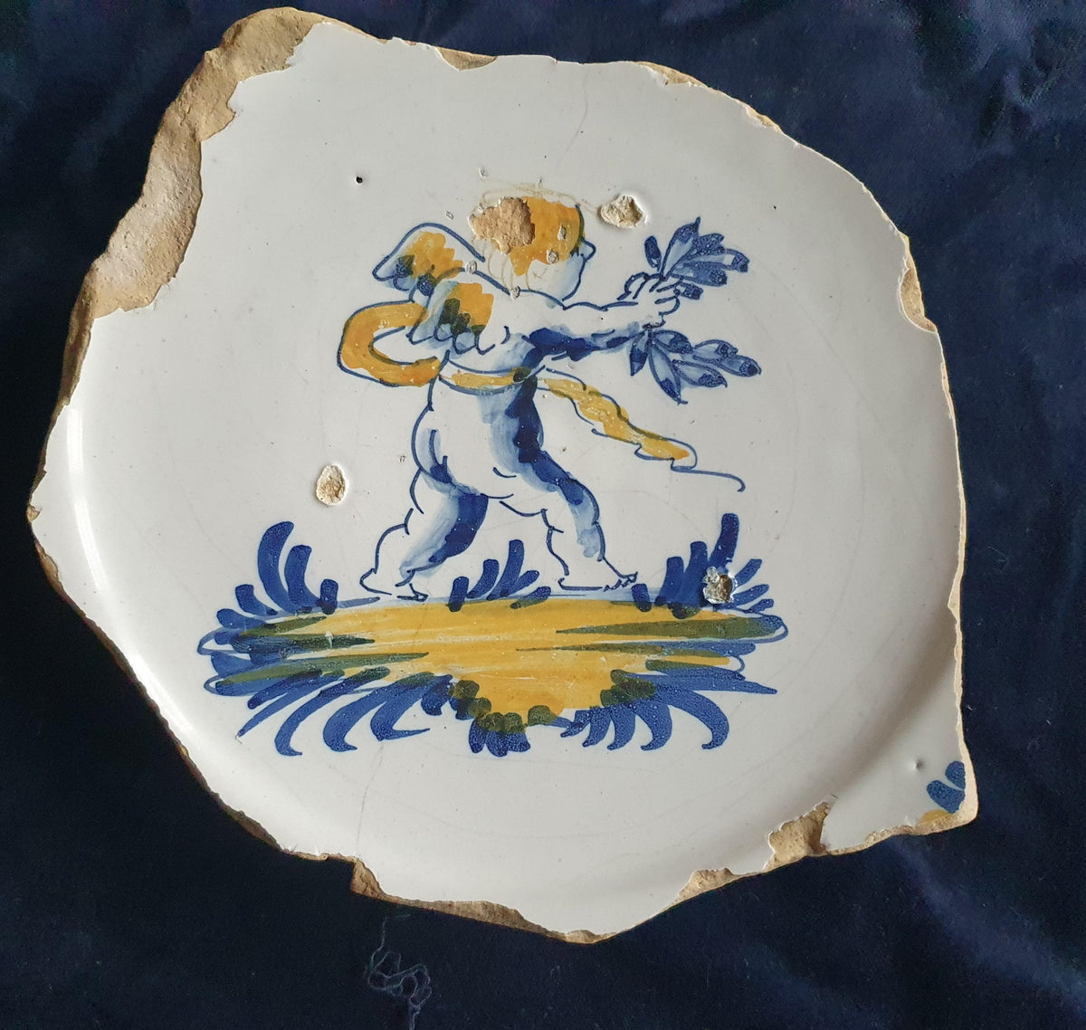 A rare, large shard from a plate, featuring a depiction on the base of a striding putto with a laurel wreath. 17th.