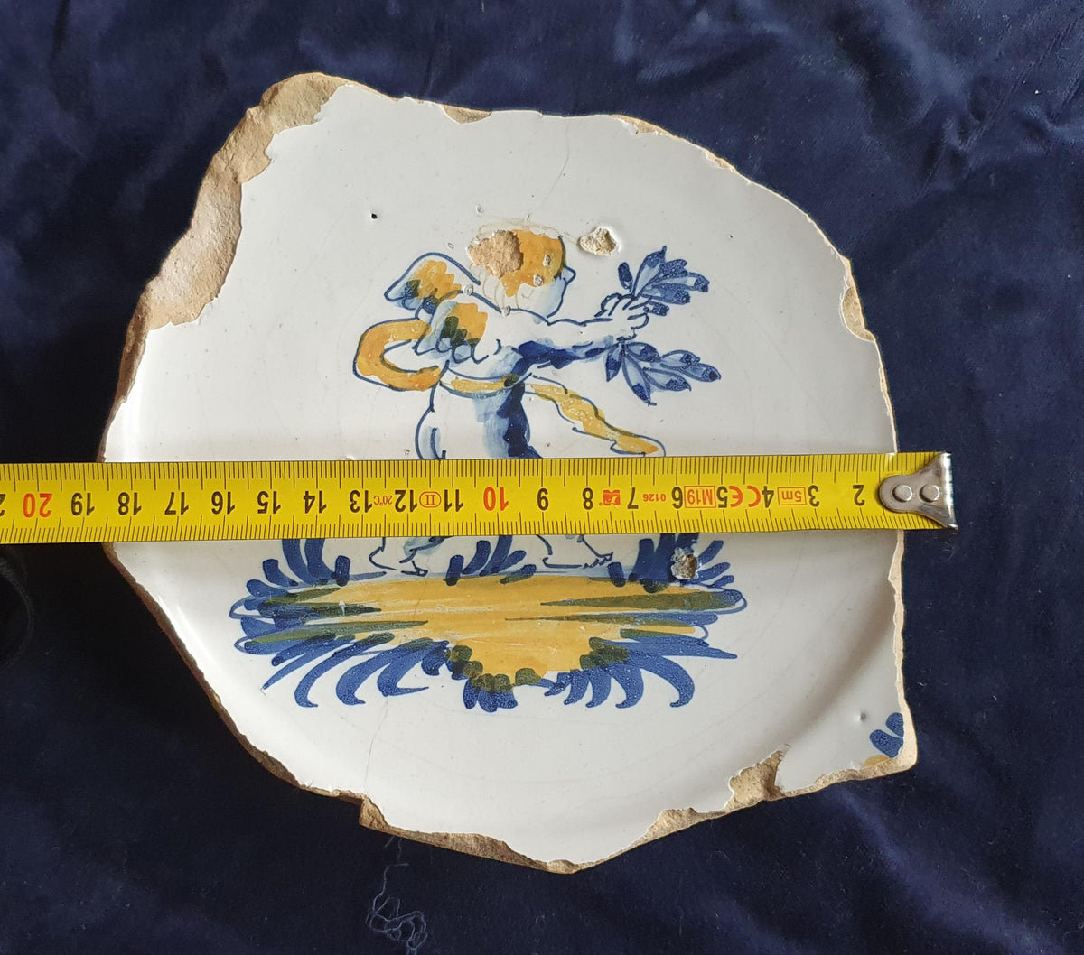 A rare, large shard from a plate, featuring a depiction on the base of a striding putto with a laurel wreath. 17th.