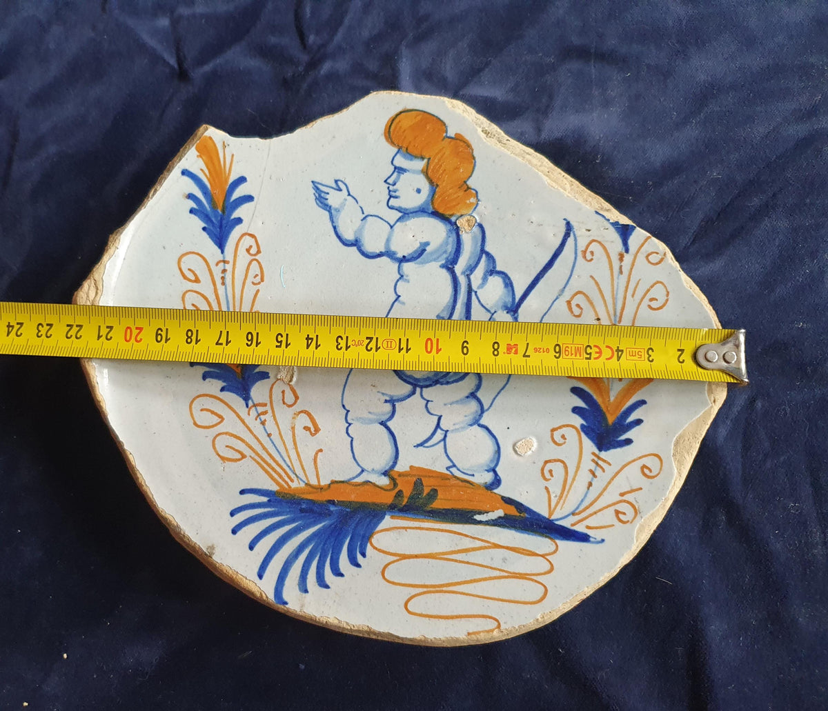 A rare, large shard from a plate, featuring a depiction on the base of a striding putto with a bow . 17th
