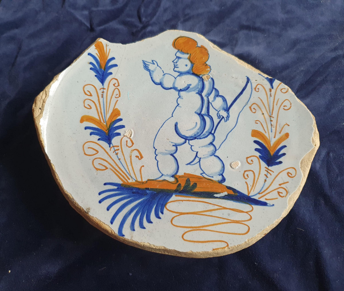 A rare, large shard from a plate, featuring a depiction on the base of a striding putto with a bow . 17th
