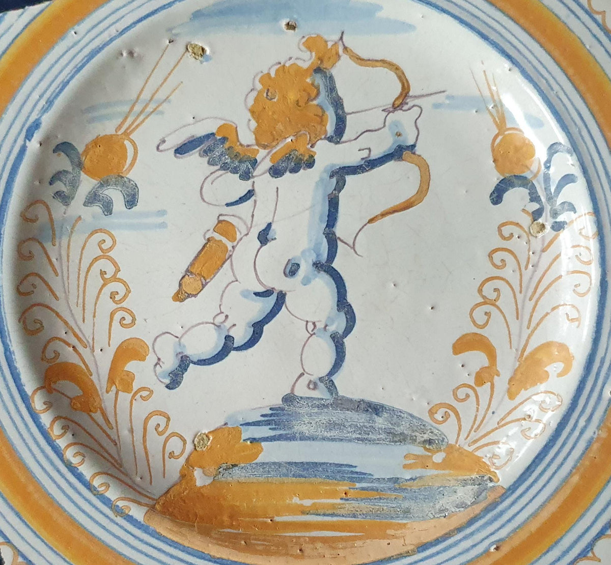A rare, large shard from a plate, featuring a depiction on the base of a striding putto with a bow and arrow. 17th