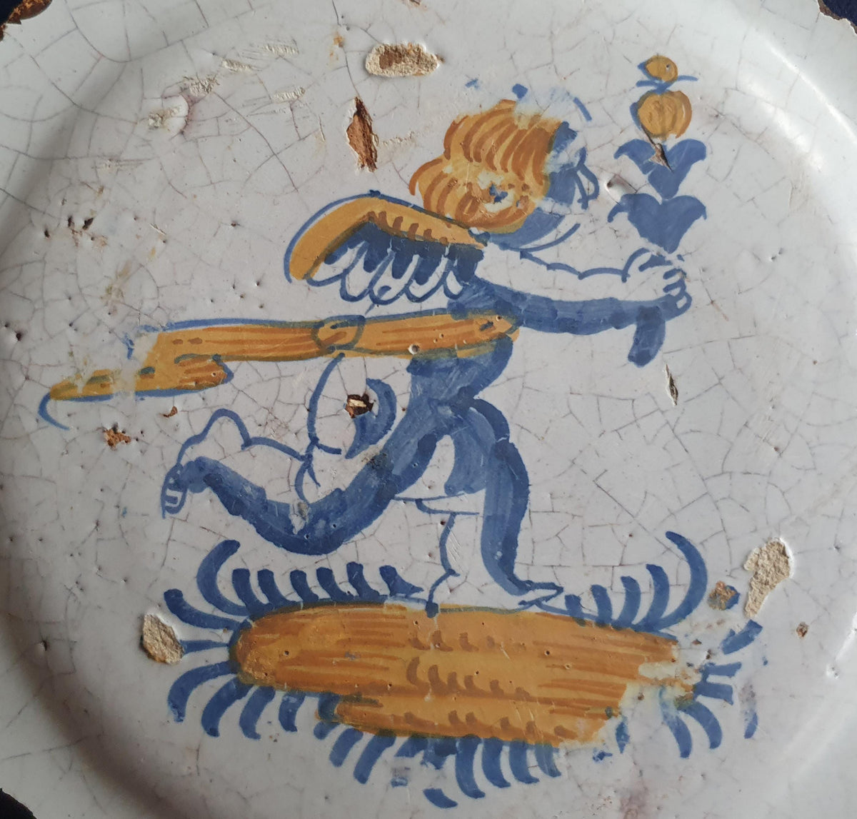 A rare, large shard from a plate, featuring a depiction on the base of a striding putto with a flower. 17th.