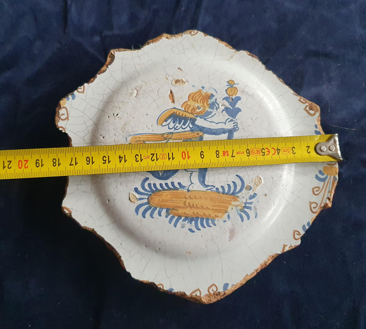 A rare, large shard from a plate, featuring a depiction on the base of a striding putto with a flower. 17th.