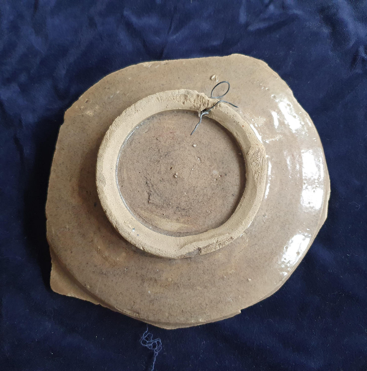 A rare, large shard from a plate, featuring a depiction on the base of a striding putto with a laurel wreath. 17th.